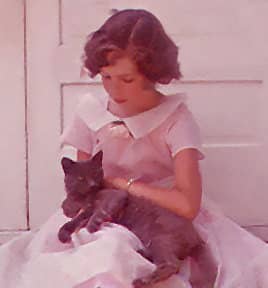 Vintage photograph of young betticlay, surface pattern designer on farmhouse steps, holding a cat.